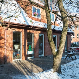 Außenansicht der Kita Wittekstraße mit Schnee auf dem Dach und im Garten